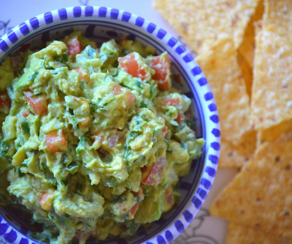 the finished guacamole in a bowl with some chips
