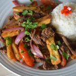 a plate of the finished lomo saltado with rice