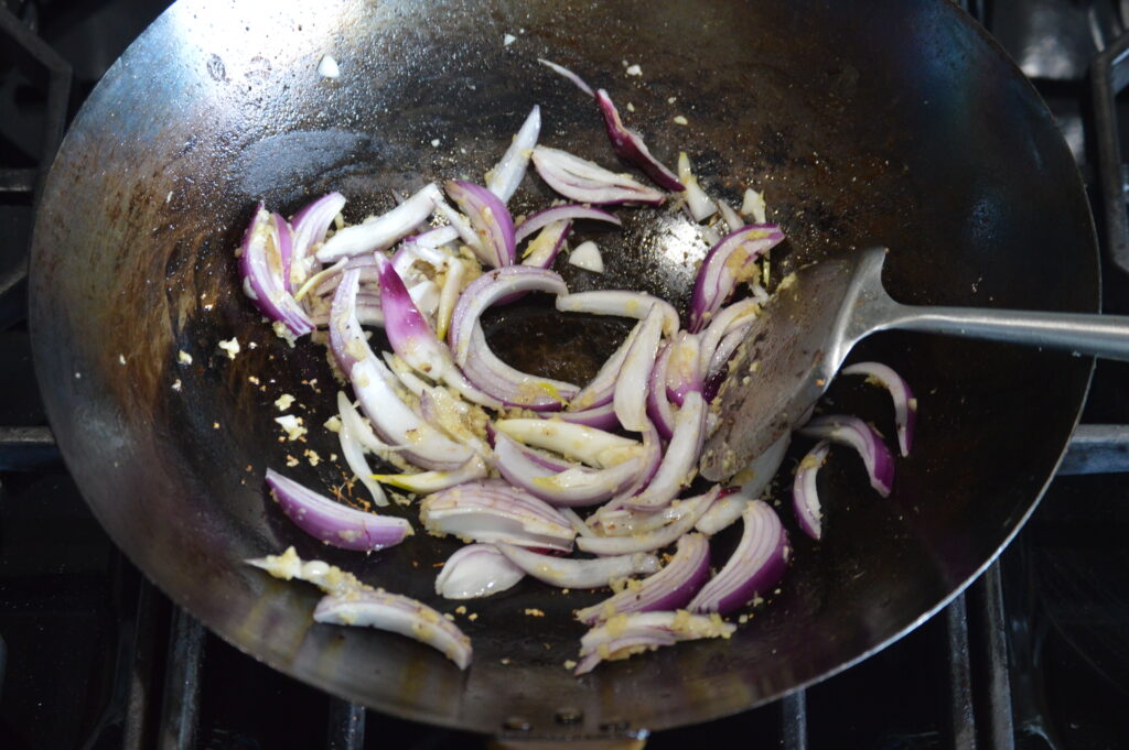 stir frying the onion with the aromatics