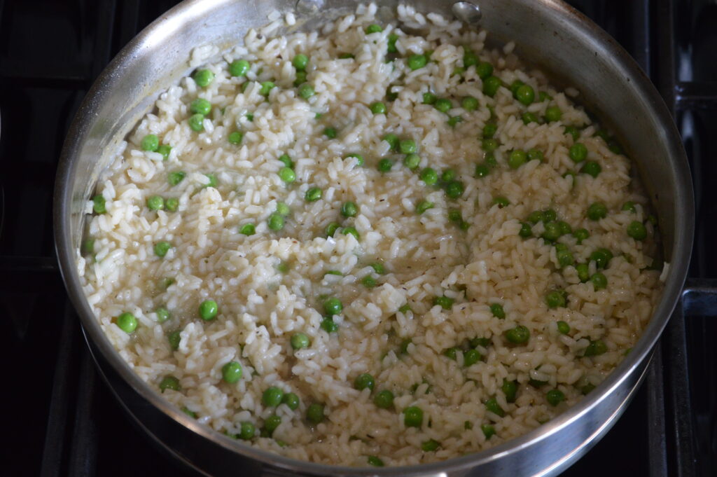 the peas, cheese, and butter is added and mixed into the risotto