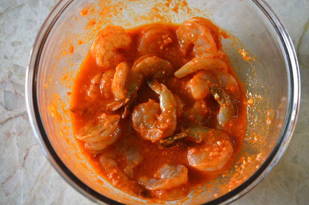 the shrimp is marinating in the red curry