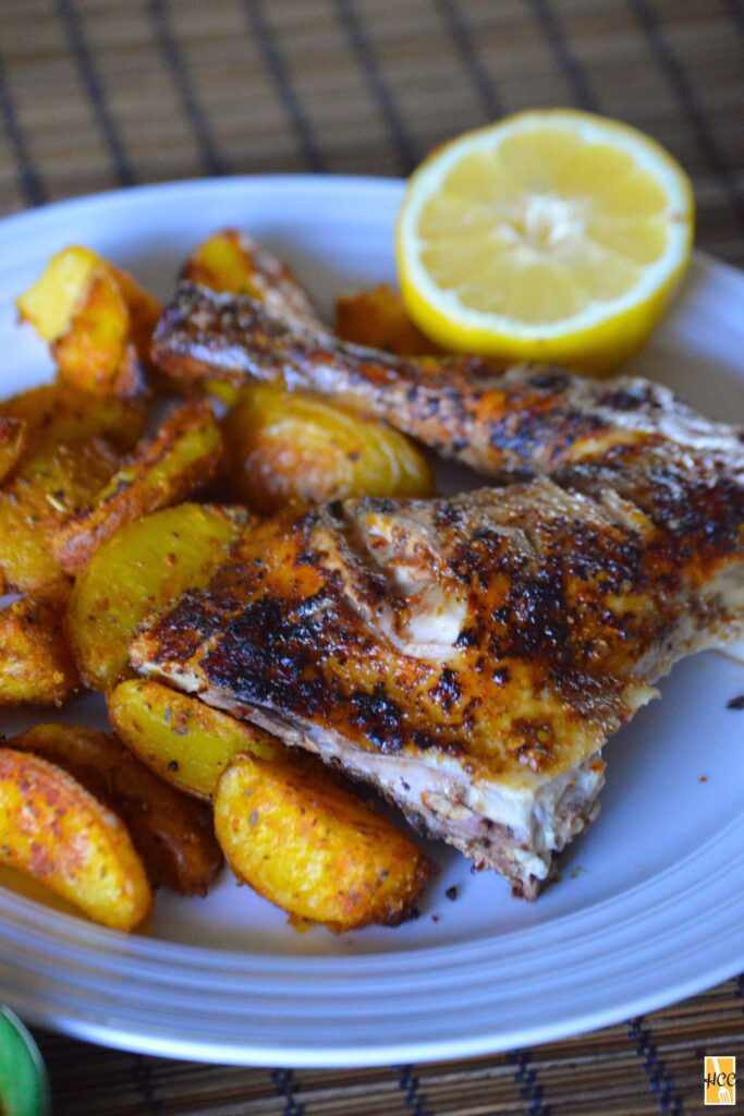 a leg and thigh portion of the piri piri chicken with potatoes