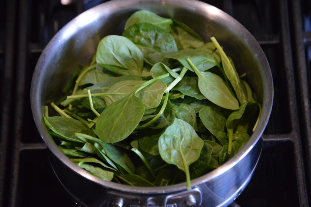 a big handful of spinach is added to the pot